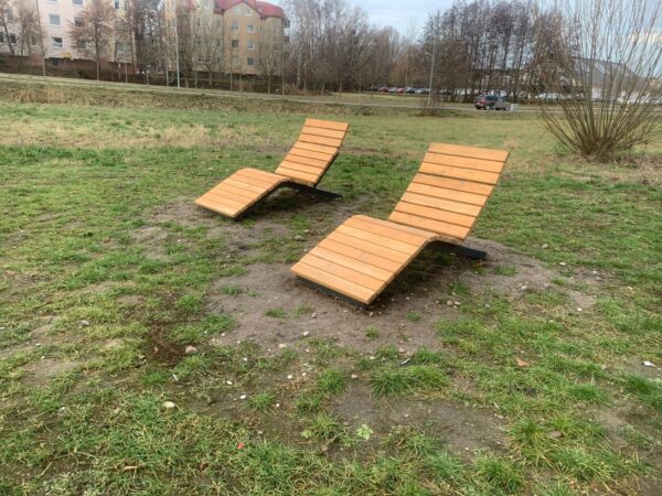 Nowoczesny leżak miejski z drewna, wykonany przez renomowanego producenta, idealny do przestrzeni publicznych i rekreacyjnych