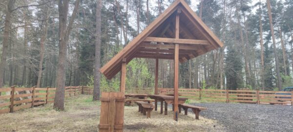 Nowoczesna mała architektura z drewna, idealna do przestrzeni publicznych i prywatnych ogrodów. Drewniane elementy, takie jak altana, pergola czy ławka, łączą estetykę naturalnego materiału z funkcjonalnością. Konstrukcja wykonana z trwałego i odpornego na warunki atmosferyczne drewna, podkreśla ekologiczną i minimalistyczną stylistykę. Perfekcyjne rozwiązanie do parków, tarasów i przestrzeni rekreacyjnych.