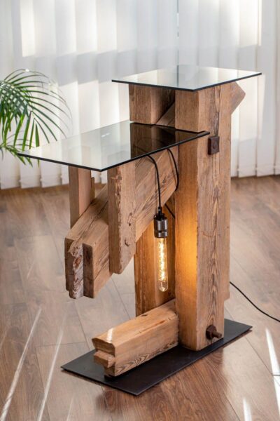 Ręcznie wykonana lampa ze starego drewna z widoczną strukturą słojów, wyposażona w żarówkę Edison, emitującą ciepłe, przytulne światło. Industrialny design łączy surowość naturalnego materiału z nowoczesnym oświetleniem