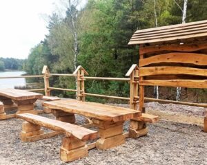 Wytrzymały ławostół parkowy z litego drewna, idealny na szlaki turystyczne, do parków i stref rekreacyjnych, wykonany z tradycyjnymi ciesielskimi łączeniami i zabezpieczony ochronnymi olejami na warunki atmosferyczne. obiekty małej architektury