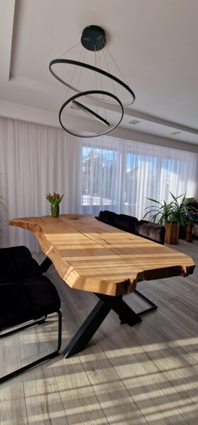 drewniany stól do jadalni, duzy salon z przestronnym wejścim na taras, w centralnym punkcie znajduje sie drewniany stół z plastra drewna z naturalnym wykończeniem i kształtem typu offlis, live edge , stól z naturalnego drewna , duży stół do domu